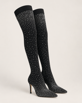 Black knee-high boots with sparkling embellishments on a light gray background