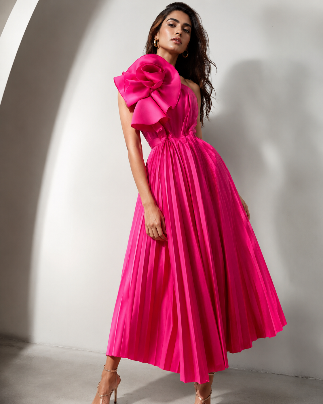 Woman wearing a bright pink dress with a large floral detail on a white background