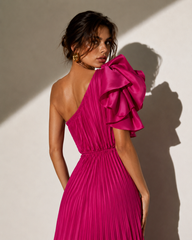 Woman wearing a vibrant pink one-shoulder dress against a neutral background